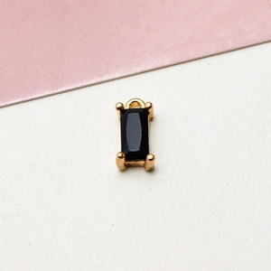 Macro detail of rectangular black zircon pendant with gold-plated four-prong setting
