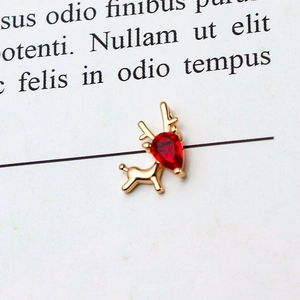 Detail of golden reindeer pendant featuring a red pear-shaped zircon gemstone inlay