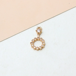 Detail eines goldenen runden Blumenanhängers mit weißen Zirkonia-Steinen für Schmuck