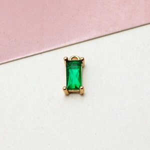 Macro shot of gold-plated emerald-cut green zircon pendant with metallic ring for DIY jewelry