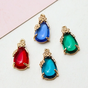 Detailed close-up of water-drop crystal pendants with gold floral edges in four colors