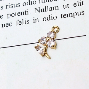 Macro detail of a gold floral pendant with clear zircons on a vintage book page