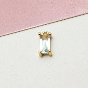 Macro shot of rectangular baguette-cut light blue zircon pendant with gold plated bail