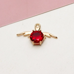 Close-up of red heart zircon pendant with gold wings for DIY necklace jewelry making