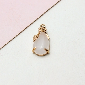 Macro detail of pink crystal teardrop pendant with gold flower frame for DIY jewelry