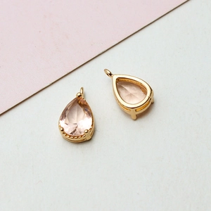 Detailaufnahme rosa birnenförmiger Glasanhänger mit Goldfassung für die Schmuckherstellung