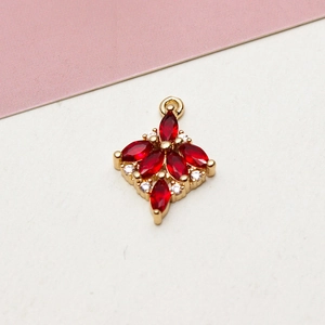 Macro detail of a 14k gold plated heart pendant with red marquise zircon flower petals