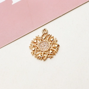 Close-up of gold-plated circular flower pendant with micro-set zircons and tiny heart motifs