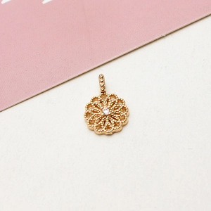 Detailed macro view of gold-plated hollow flower pendant with sparkling center zircon