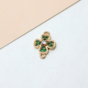 Detailed view of gold plated four leaf clover connector with green pavé cubic zirconia