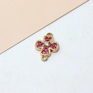Detailed macro view of a gold-plated clover pendant with pink zircons for DIY jewelry