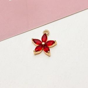 Macro shot of 18k gold plated five-petal flower pendant with red marquise zircon stones
