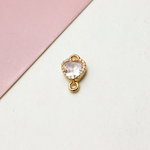 Macro d'un pendentif cœur en zircon avec cadre perlé doré et deux anneaux de jonction