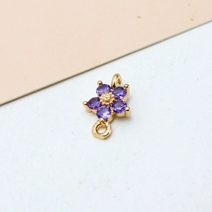 Detailed close-up of a gold-plated flower pendant with five purple zircons and double loops