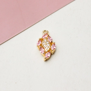 Makroaufnahme von vergoldetem Tropfenanhänger mit rosa Zirkonia und weißen Kristallen