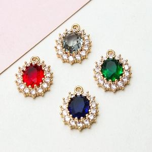 Close-up of oval zircon pendants in four colors with gold plating for jewelry making