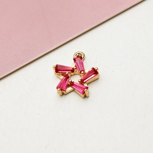 Dettaglio di un ciondolo a stella dorato con zirconi rosa per creazione gioielli DIY
