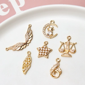 Macro detail of 6 gold plated charms featuring zircons for DIY jewelry making