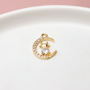 Macro detail of gold-plated crescent moon pendant with zircon-studded calf motif