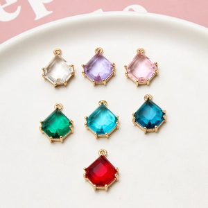 Colorful geometric crystal pendants with gold copper edges in a white decorative tray