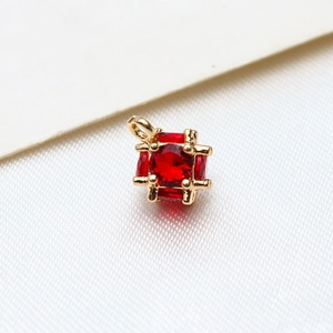 Macro shot of cubic red zircon pendant with gold plated copper frame for DIY jewelry