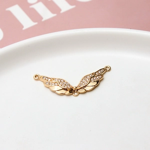 Detailed view of a gold-plated angel wing connector with sparkling cubic zirconia inlay