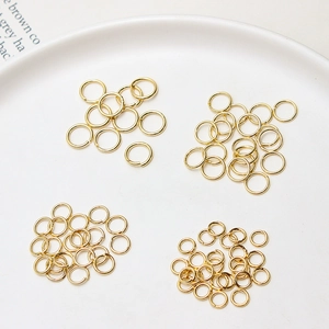 Détail d'anneaux ouverts plaqués or 14 carats pour création de bijoux sur plat blanc
