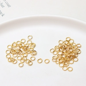 Détail macro d'anneaux ouverts plaqués or 14k pour création de bijoux sur plateau blanc