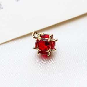 Detailed macro view of a red faceted cubic zircon pendant with gold plated claw setting