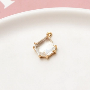 Macro detail of geometric pentagon crystal pendant with gold claw setting and ring