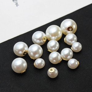 Détail macro de perles blanches brillantes avec base dorée sur fond de tissu noir
