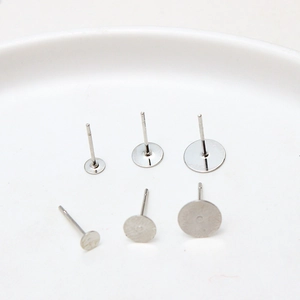 Detailed view of silver DIY earring posts with flat pad bases in three different sizes