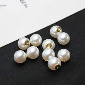 Détail macro de fermoirs de boucles d'oreilles en perles blanches brillantes et socle doré