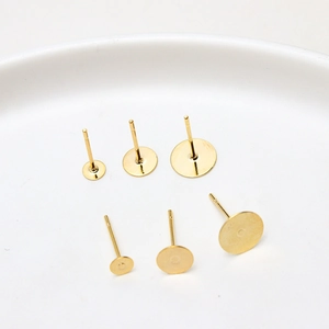 Macro detail of gold plated flat pad earring posts in three different sizes for DIY jewelry