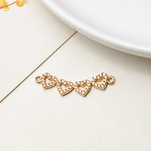 Détail de connecteurs en forme de cœurs entrelacés plaqués or et zircons pour bijoux DIY