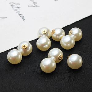 Vue macro de perles blanc crème à haute brillance avec attaches dorées pour bijoux DIY