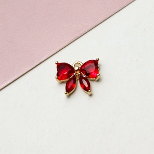 Macro shot of gold-plated red zircon bow pendant featuring heart and marquise cut stones