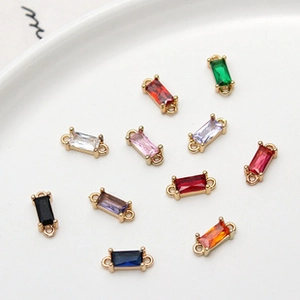 Close-up of colorful square crystal glass pendants with gold-plated edges for DIY jewelry