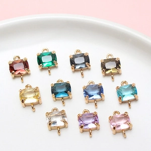 Macro view of rectangular crystal glass charms in gold settings for DIY jewelry making