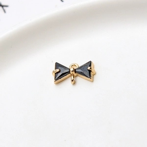 Detailed view of gold bow pendant with black cubic zirconia and dual hanging loops