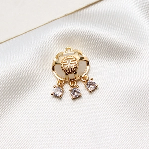 Vue macro du pendentif cadenas Fu doré avec pierre blanche et accents en zircon