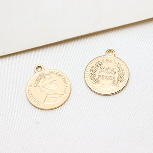 Vue macro détaillée de pendentifs pièces vintage dorés avec Elizabeth II et Dos Pesos