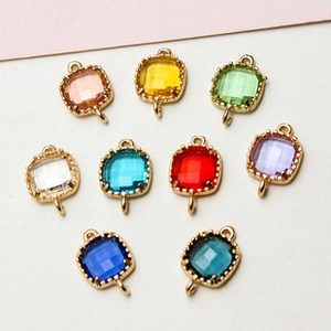 Macro detail of nine colorful square gemstone pendants with gold plated metal borders