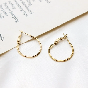 Detailed view of polished gold plated hoop earrings featuring a hinged closure