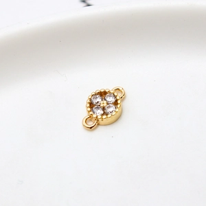 Macro shot of gold-plated copper flower pendant with four cubic zirconia stones