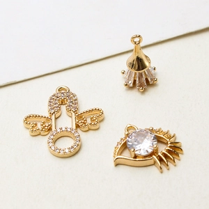 Detailed macro view of three golden jewelry pendants with zircon inlays on white texture