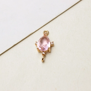Detailansicht eines rosa Kristallanhängers mit Goldbeschichtung und Zirkonia-Akzenten