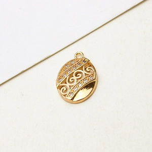 Detailed close-up of golden filigree oval pendant with sparkling zircon insets for DIY jewelry