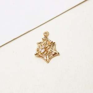 Macro shot of gold plated spider web pendant with sparkling white cubic zirconia stones