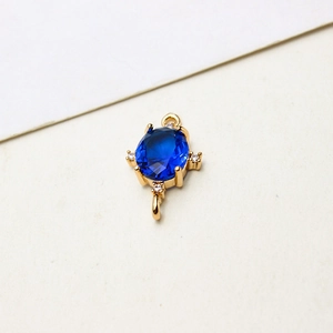 Makro-Detail von ovalem blauem Edelstein-Anhänger mit Vergoldung und Doppelringen für DIY-Schmuck